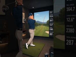 Frank playing golf on a simulator with great numbers